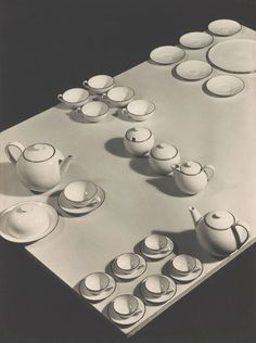 a table topped with lots of cups and saucers on top of a white surface