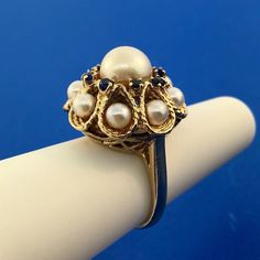 * Vintage 14K Yellow Gold Pearl Sapphire Princess Style Cocktail Ring * Ring Size: 5.75 * Top of ring measures: 7/8" x 7/8" * Band width: 1/8"  * Height: 3/4" * Center Pearl measures: approximately 8 mm * Accent Pearls measure: approximately 4 mm each * Sapphires measure: approximately 2.0 mm each * Weight: 9.7 tgw * Marked: 14K * Condition: Great  * G881    Exported By ExportYourStore :) Vintage Pearl Rings, Pearl Rings Vintage, Princess Style, Vintage Pearls, Gold Pearl, Pearl Ring, Cocktail Rings, Favorite Jewelry, Sapphire