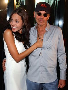 an older man and young woman posing for the camera with their arms around each other