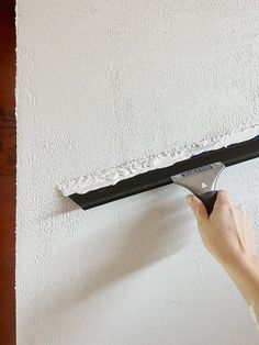 a person using a paint roller on a wall