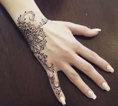 a woman's hand with a henna tattoo on it