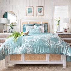 a bed with blue and white comforter in a bedroom next to two nightstands