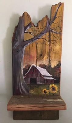 a piece of wood with a barn and sunflowers painted on it, sitting on a shelf