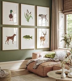 a living room with green walls and pictures on the wall above the couch, along with vases filled with flowers