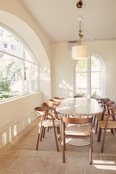 a dining room table and chairs in front of an arched window