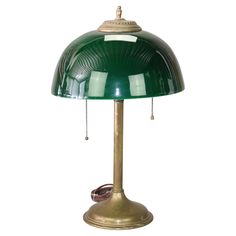 a green table lamp sitting on top of a white wall