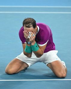 a man kneeling down on top of a tennis court while holding a racquet