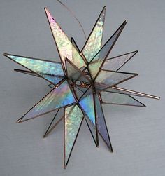 an ornament made out of metal and colored with iridescent colors on it