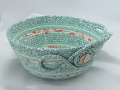 a blue and white bowl with flowers on it's sides, sitting on a white surface