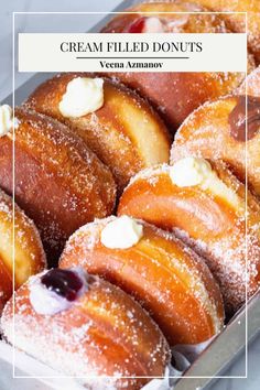 a box filled with lots of donuts covered in powdered sugar and toppings