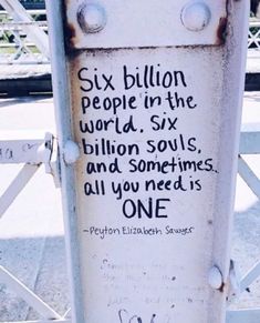 a white pole with graffiti on it and writing on the side that says six billion people in the world, six billion soul's and sometimes all you need is one