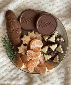 a plate with cookies, oranges and candies on it