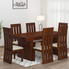 a dining room table and chairs with white cushions