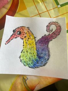 a drawing of a colorful bird on white paper