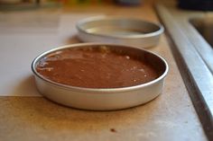 two metal pans filled with food sitting on top of a counter next to each other