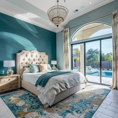 a bedroom with blue walls and a large bed next to a sliding glass door that leads to an outdoor swimming pool