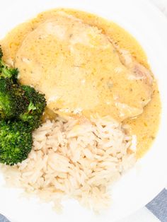 a white plate topped with rice and broccoli on top of a blue and white checkered table cloth