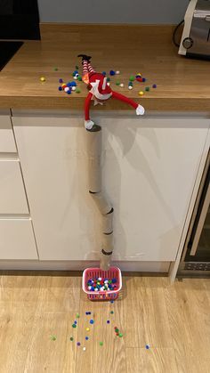 an elf is standing on top of a roll of toilet paper and sprinkles