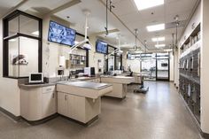 the inside of a medical office with lots of desks and monitors on the wall