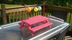 a pink picnic table with balloons on it