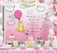 a winnie the pooh birthday party with pink and gold decorations, balloons and desserts