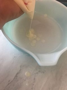 a person is pouring liquid into a bowl