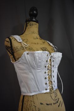 -------------------Corset------------------ This historical corset is made with steel boning and canvas layered with white cotton twill fabric. The cups have flower decorations for an intimate feel. ----------------Sizing------------------- Please reference the last slide for measurements. Use the bust measurements when ordering. For a custom fit please provide the following measurements: bust underbust -------------SHIPPING------------ Please allow 4-6 weeks for the corset to be made and shippe Regency Short Stay, Luxury Corset With Historical Design, Medieval Corset Dress White, Luxury Regency Wedding Corset, Luxury Historical Design Corset, Luxury Historical Design Corset For Costume, Luxury Wedding Regency Style Corset, Luxury Historical Corset For Costume, Corset Historical