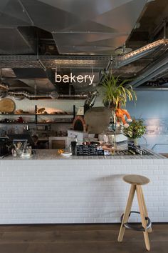 an empty bakery counter with stools in front of it