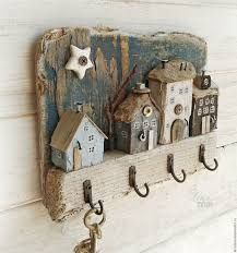 a wooden shelf with hooks and houses on it