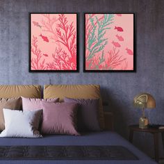 two paintings on the wall above a bed in a room with purple walls and pillows