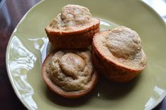 three muffins on a green plate sitting on a table