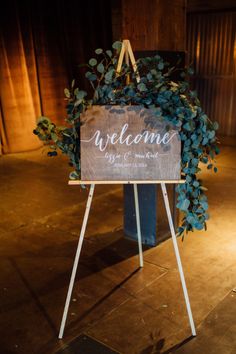 a welcome sign sitting on top of a wooden easel