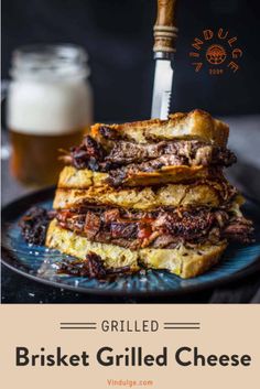 grilled brisket grilled cheese sandwich on a blue plate with a beer in the background