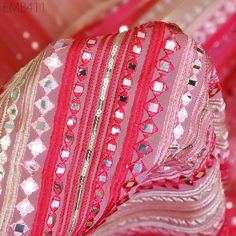 pink and gold sequins are on the side of a piece of fabric that has been draped over