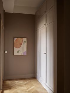 an empty room with white cabinets and a painting hanging on the wall in front of it