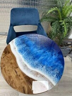 a blue and white plate sitting on top of a wooden table next to a chair