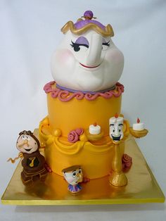 there is a cake made to look like beauty and the beast characters on top of it