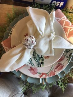 a stack of plates with napkins and flowers on them