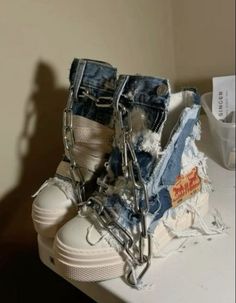 a pair of shoes with chains attached to them sitting on a counter next to a bag