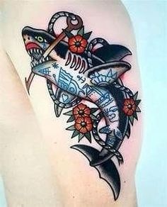 a tattoo design on the back of a woman's thigh with a shark and anchor