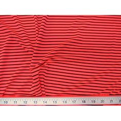 a red and black striped fabric with a ruler