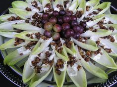 an arrangement of fruits and vegetables on a platter with white frosted icing