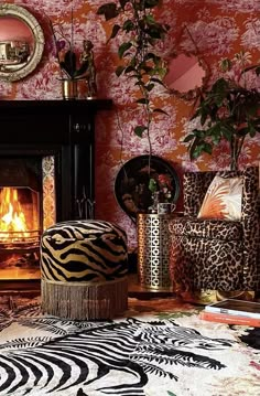 a living room filled with furniture and a fire place in the fireplace surrounded by animal print rugs