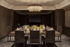 an elegant dining room with chandelier and large table set for six people in front of a projection screen