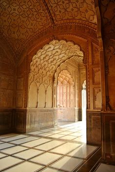 the inside of an ornate building with tile flooring and arches on either side of it