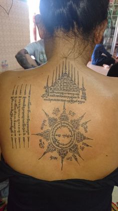 the back of a woman's neck with tattoos on it