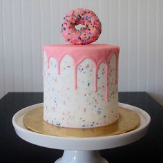 a cake with sprinkles and a donut on top