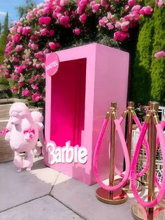 there is a pink box that says barbie on it and two gold stands next to it