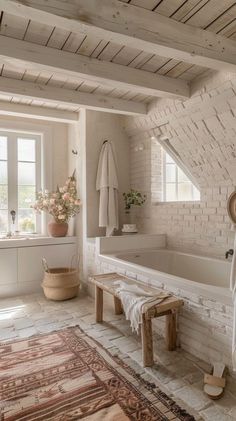 a bathroom with a large bath tub next to a window and rug on the floor