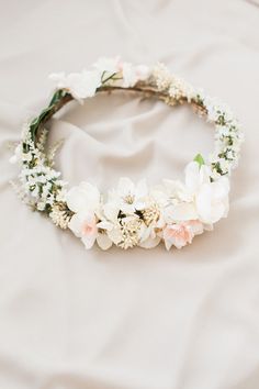 a white flower crown on top of a bed